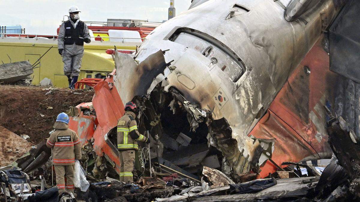 Bomberos e investigadores examinan los restos del avión de Jeju Air en el Aeropuerto Internacional de Muan, Corea del Sur, el lunes 30 de diciembre de 2024. La aeronave se estrello el domingo; 179 personas murieron y dos sobrevivieron.