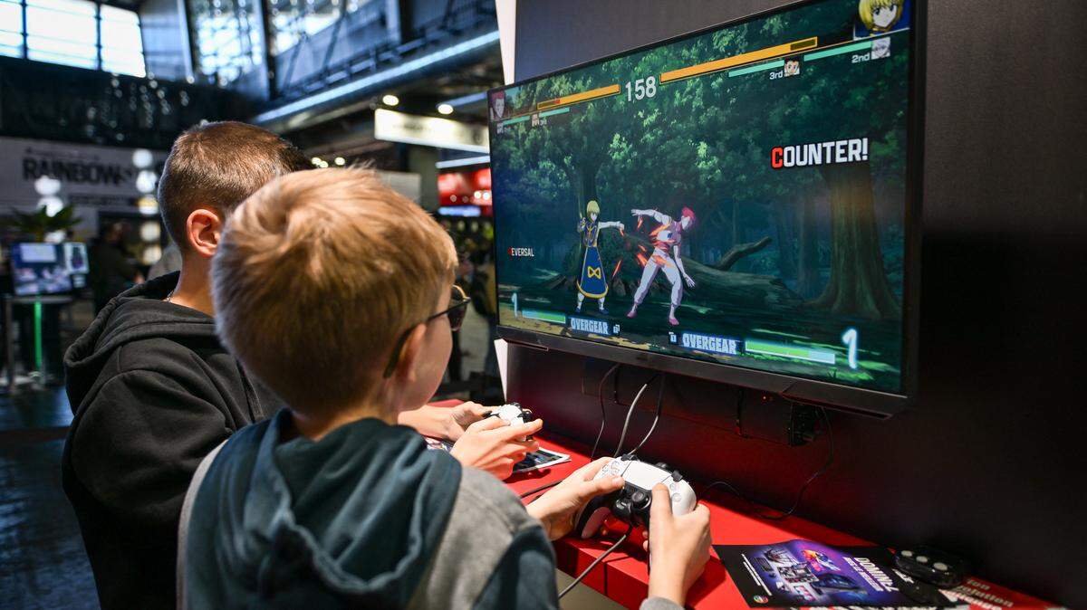 Dos niños juegan con un PlayStation 5 durante la Semana del Juego en París 2024, en la capital francesa el 23 de octubre de 2024.