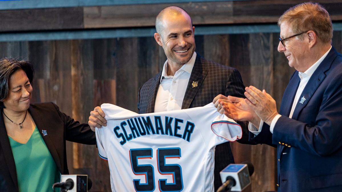 Skip Schumaker (centro) sonríe en su presentación como nuevo manager de los Marlins, el 3 de nociembre de 2022 en el loanDepot park de Miami. A su izquierda la gerente general Kim Ng y el propietario principal Bruce Sherman.