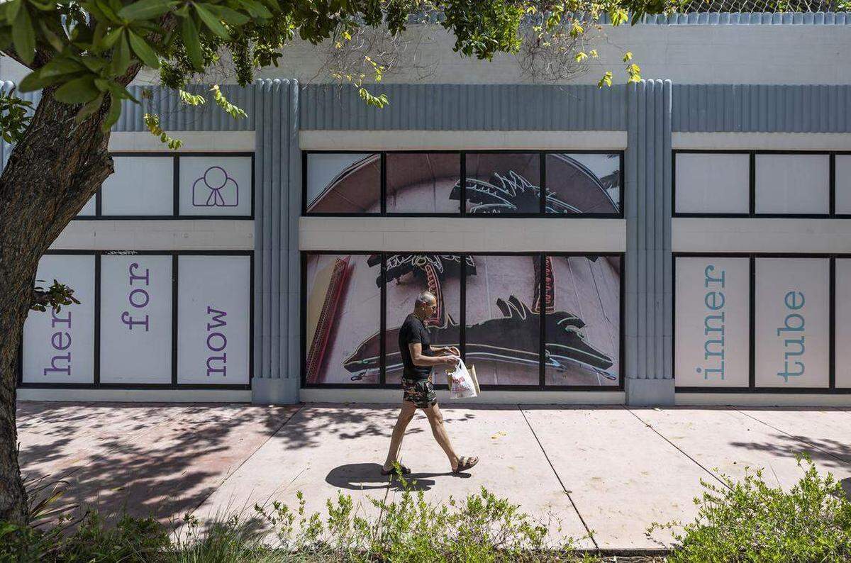 Un hombre pasea frente a escaparates históricos vacíos de estilo art déco que fueron incorporados a The Goodtime Hotel, inaugurado en 2021 en Washington Avenue como parte de un esfuerzo de revitalización que no ha dado los resultados esperados.