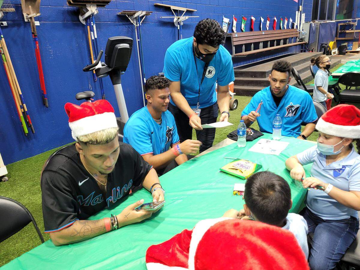 José Salas (centro) en una actividad de Navidad en el parque de los Marlins junto a los hermanos Victor Mesa Jr. y Victor Victor Mesa (der.).