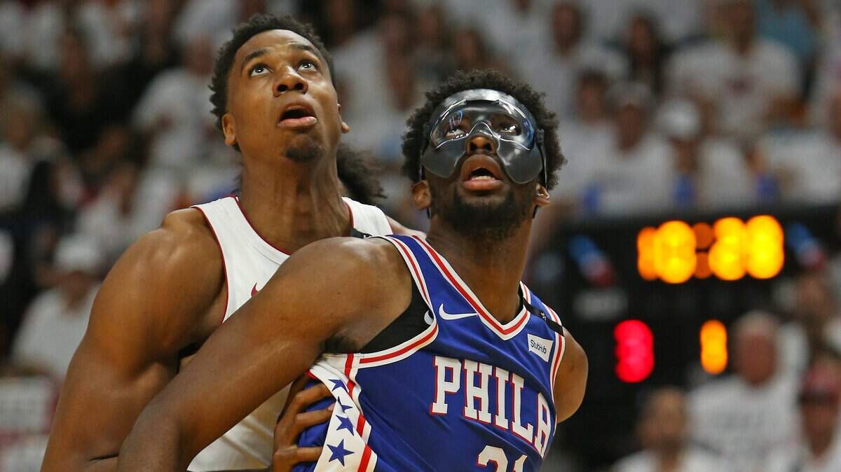 El centro del Heat Hassan Whiteside (izq.) lucha por pelota con Joel Embiid, de Filadelfia, en el primer cuarto del partido de playoff, el 19 de abril de 2018 en Miami.