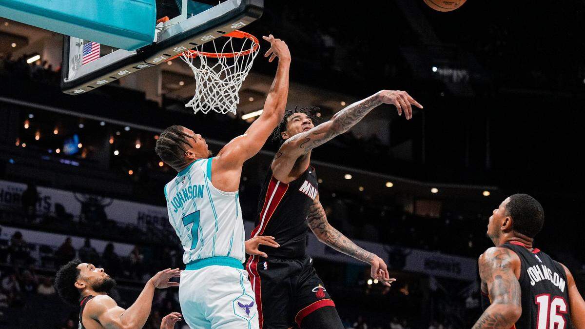 El jugador del Heat de Miami Kel’el Ware (centro) bloquea un tiro de Keyontae Johnson, de los Hornets, en el partido de pretemporada celebrado el 8 de octubre de 2024 en Charlotte.