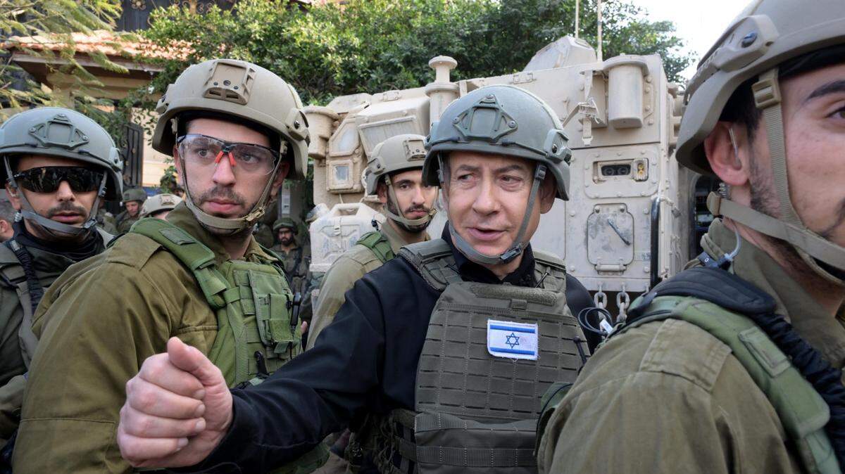 El primer Ministro israelí Benjamin Netanyahu (C) reacciona mientras inspecciona las tropas israelíes en el norte de la Franja de Gaza, el 25 de diciembre de 2023. Netanyahu recorrió el norte de la Franja de Gaza el lunes y prometió continuar la lucha, dijo la oficina del primer ministro.