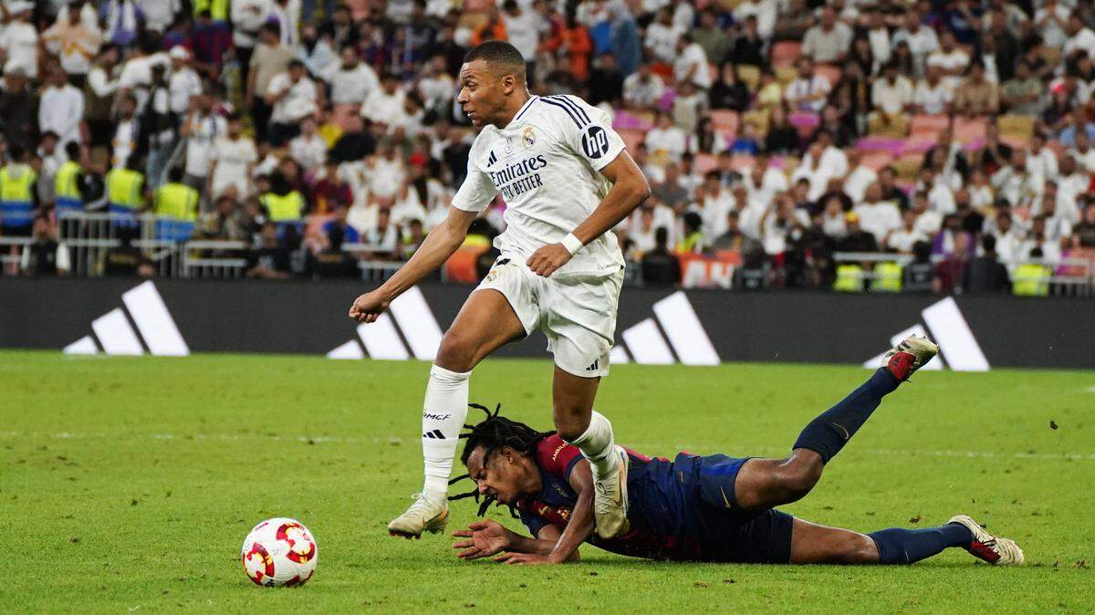 El delantero del Real Madrid Kylian Mbappé conduce el balón ante la marca de Jules Koundé, del Barcelona, en el partido celebrado el 11 de enero de 2025 en Yeda, Arabia Saudita.