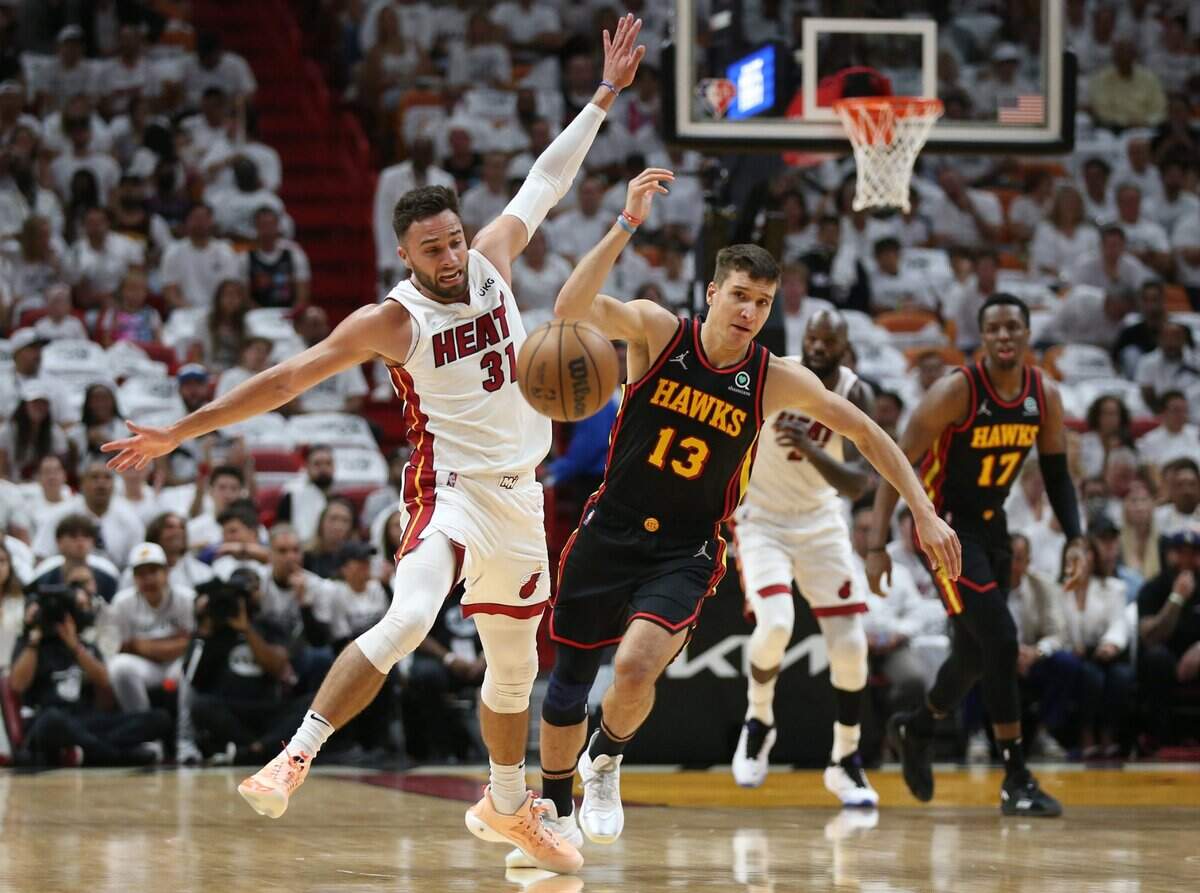 El jugador del Heat Max Strus (31) y Bogdan Bogdanovic, de los Hawks de Atlanta, luchan por la pelota en el segundo juego del playoffs de primera ronda, celebrado el 19 de abril de 2022 en Miami.