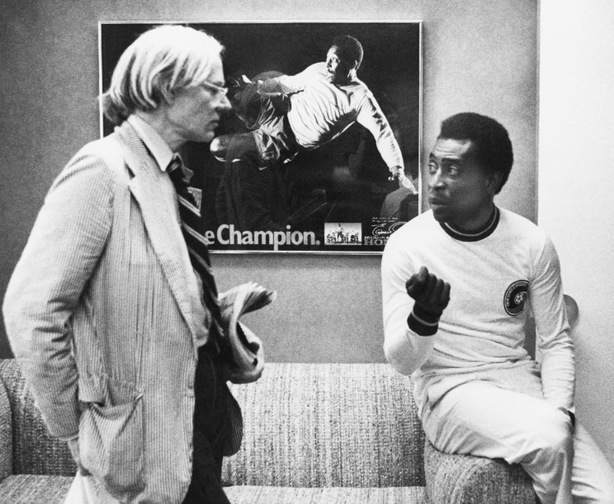 Foto de archivo. El artista Andy Warhol, a la izquierda, conversa con Pelé sobre un retrato que le estaba haciendo el 26 de julio de 1977, en Nueva York.