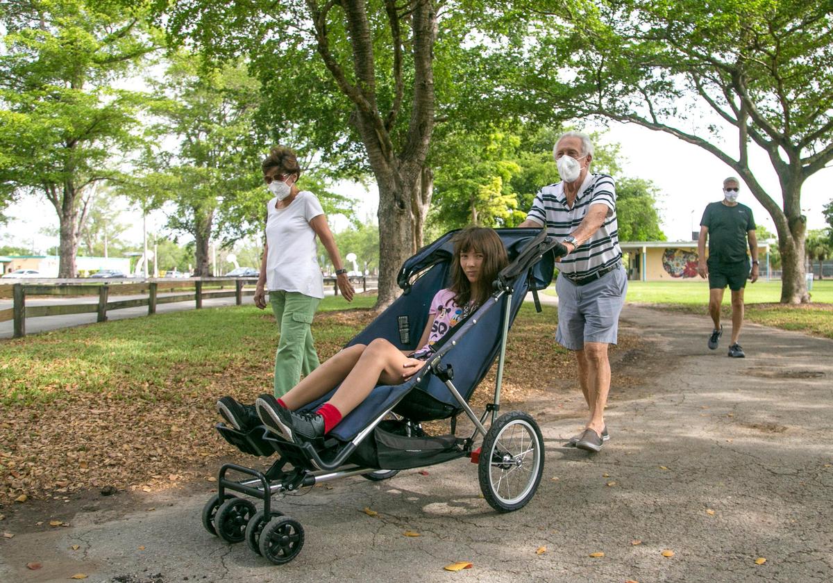 Maria Deribeaux y Gustavo Deribeaux caminan con su nieta Madison Deribeaux, de 18 años, mientras caminan por el Tropical Park. El condado de Miami-Dade levantó sus órdenes que cerraba los parques debido a COVID-19 el 29 de abril de 2020.