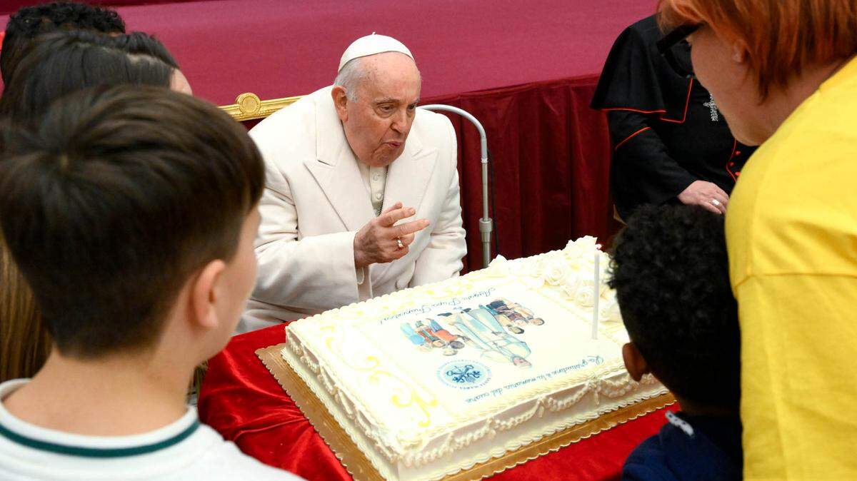 El papa Francisco sopla las velas de su torta durante la celebración de su cumpleaños 87, el domingo 17 de diciembre de 2023, en el Salón Pablo VI, en El Vaticano.