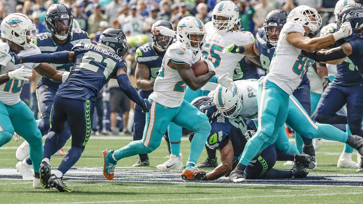 El running back de los Dolphins, De’Von Achane (28), corre con el ovoide en la primera mitad del partido contra los Seahawks, celebrado el 22 de septiembre de 2024 en el Lumen Field en Seattle, Washington.