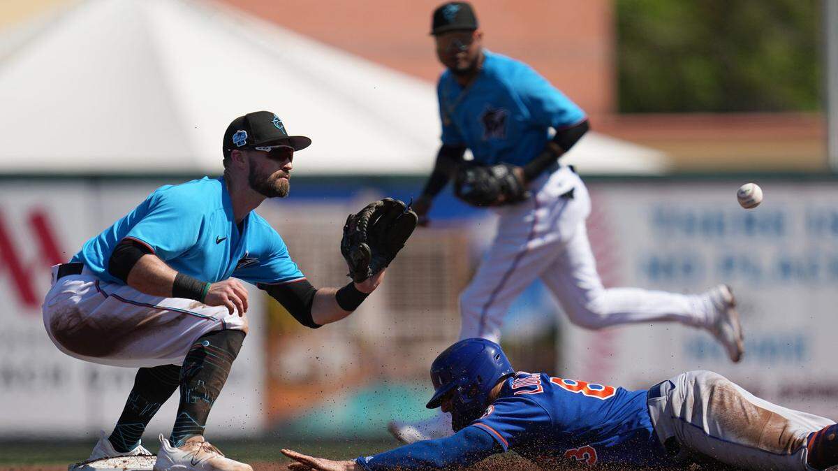 El jardinero de los Mets Tim Locastro se roba la segunda base ante la defensa de Jon Berti, de los Marlins, en el partido de pretemporada celebrado el 1ro de marzo de 2023 en el Roger Dean Stadium, en Jupiter, Florida.