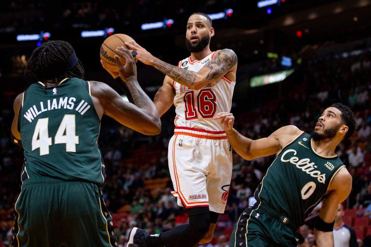 El jugador del Heat Caleb Martin trata de pasar la pelota ante la marca de Jayson Tatum (der.) y Robert Williams III, de los Celtics de Boston, en el partido celebrado el 24 de enero de 2023 en Miami.