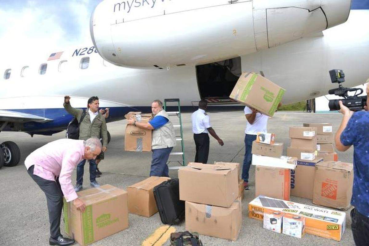 Raúl De Molina (centro) ayuda a descargar el donativo que hizo la organización SOMOS Healthcare a los damnificados de Puerto Rico.