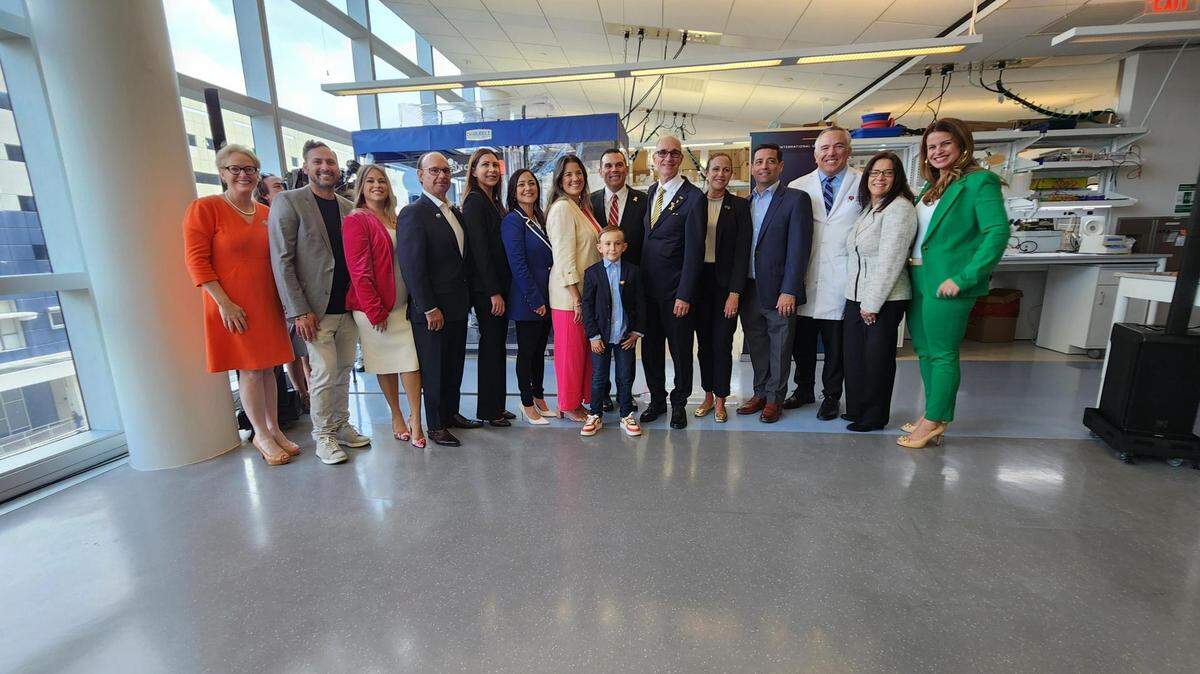 Logan (centro), rodeado de representantes de FIU, Nicklaus Children’s, Live Like Bella y funcionarios electos para celebrar la reciente colaboración de investigación.