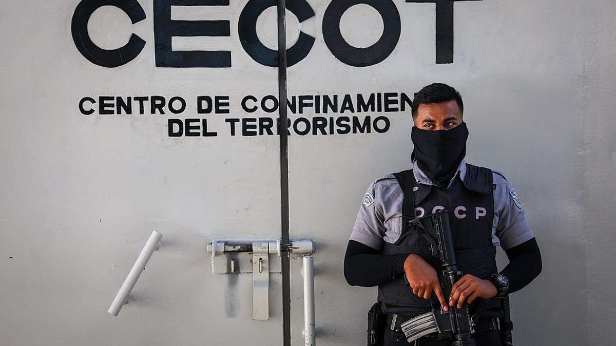 Un guardia penitenciario vigila el perímetro interior del CECOT (Centro de Confinamiento Antiterrorista), donde miles de presuntos pandilleros se encuentran encarcelados, el 15 de diciembre de 2025 en Tecoluca, El Salvador. El CECOT cobró notoriedad en 2025 cuando la administración Trump implementó su controvertida política de deportar a El Salvador a personas que, según afirmaban, eran miembros de la organización criminal venezolana Tren de Aragua y de la Mara Salvatrucha (MS-13), una pandilla cuyos miembros son históricamente salvadoreños.