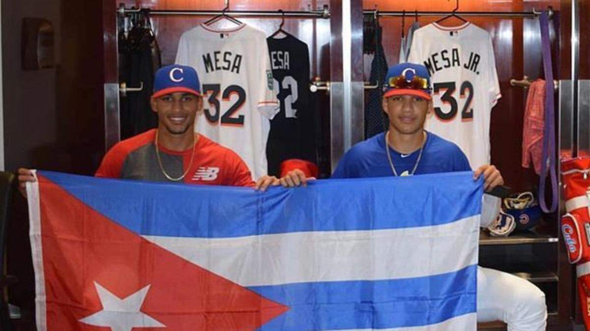 Víctor Víctor Mesa (izq.) y Víctor Mesa Jr.  posan dentro del clubhouse de los Marlins en la jornada de showcase .