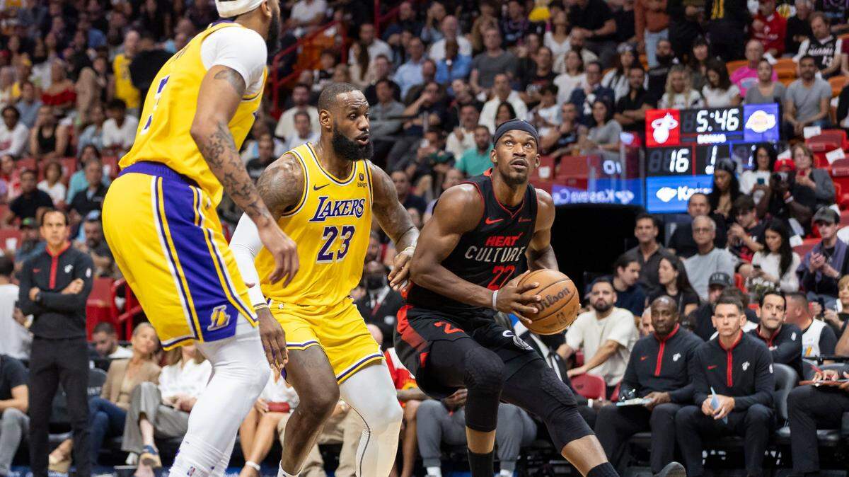 El jugador del Heat Jimmy Butler (der.) trata de entrar al aro ante la marca de LeBron James (centro), de los Lakers de Los Angeles, en el partido celebrado el 6 de noviembre de 2023 en Miami.