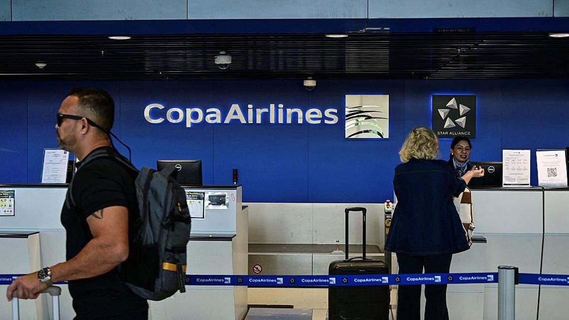 A passenger drops off her luggage at the Copa Airlines counter at Tocumen International Airport in Panama City, on December 4, 2025. Panamanian airlines Copa Airlines and Wingo suspended flights to and from Venezuela on December 3 for two days, joining eight other carriers in a temporary halt following a warning from the U.S. aviation authority about increased military activity in the Caribbean. (Photo by Martin BERNETTI / AFP via Getty Images)