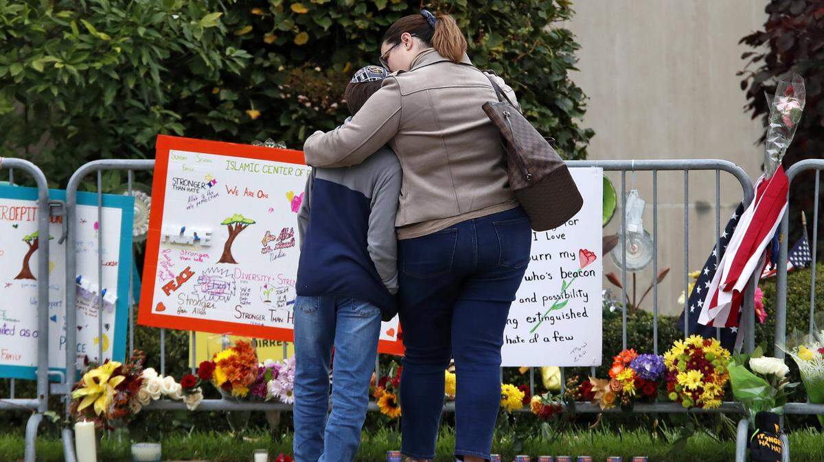 Una madre abraza a su hijo mientras guardan un momento de silencio por las víctimas del tiroteo en la sinagoga Tree of Life en Pittsburgh, el 27 de octubre de 2019, cuando se cumplió un año de la tragedia. Un hombre mató a 11 personas dentro del templo.