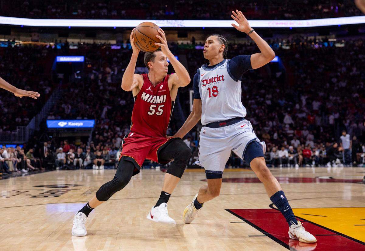 El jugador del Heat Duncan Robinson (izq.) avanza con la pelota ante la marca de Kyshawn George, de los Wizards de Washington, en el partido celebrado el 3 de marzo de 2025 en Miami, Florida.