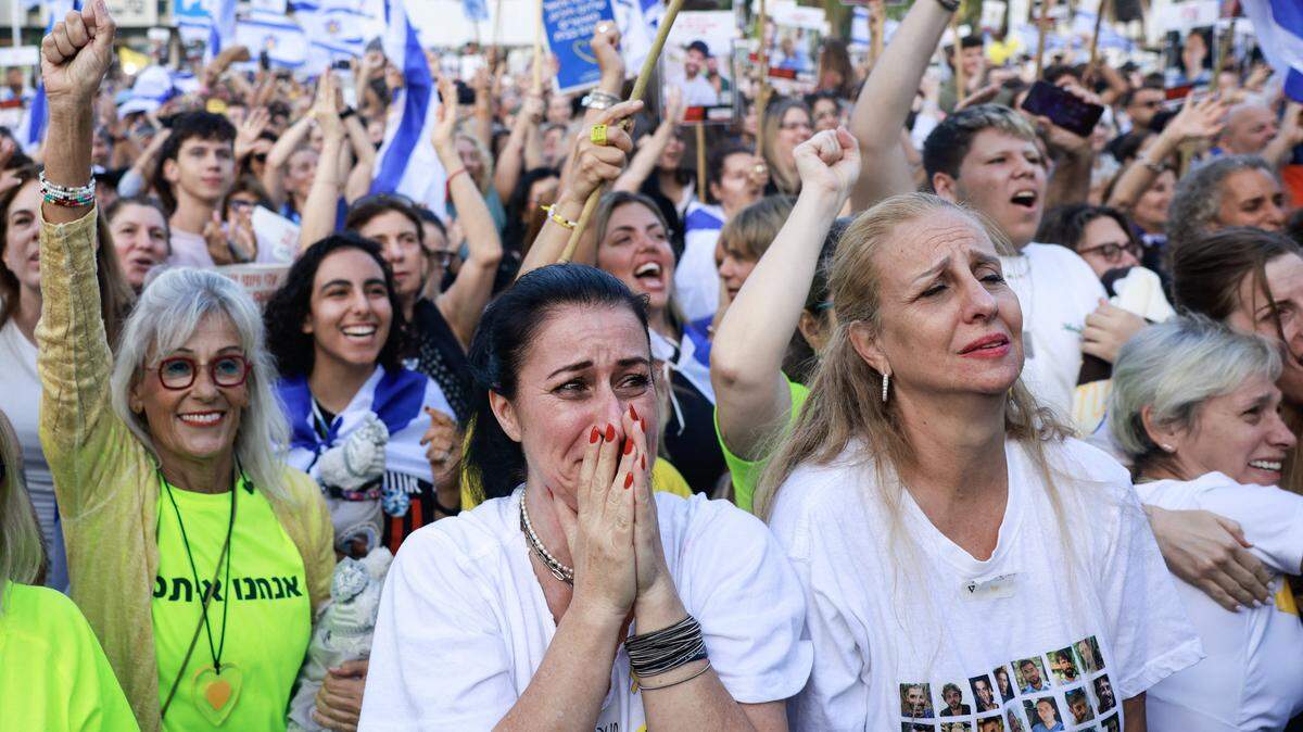 A woman reacts as people celebrate at Hostage Square in Tel Aviv as news came out that a Red Cross convoy is on its way to pick up a second group of Israeli hostages to be freed by Hamas on October 13, 2025. A Red Cross convoy is on its way to pick up a second group of Israeli hostages to be freed by Hamas as part of a Gaza ceasefire deal October 13, the Israeli military said. An army statement said the handover would take place at "an additional meeting point in the southern Gaza Strip, where several hostages will be handed over to the Red Cross." (Photo by Menahem Kahana / AFP) (Photo by MENAHEM KAHANA/AFP via Getty Images)