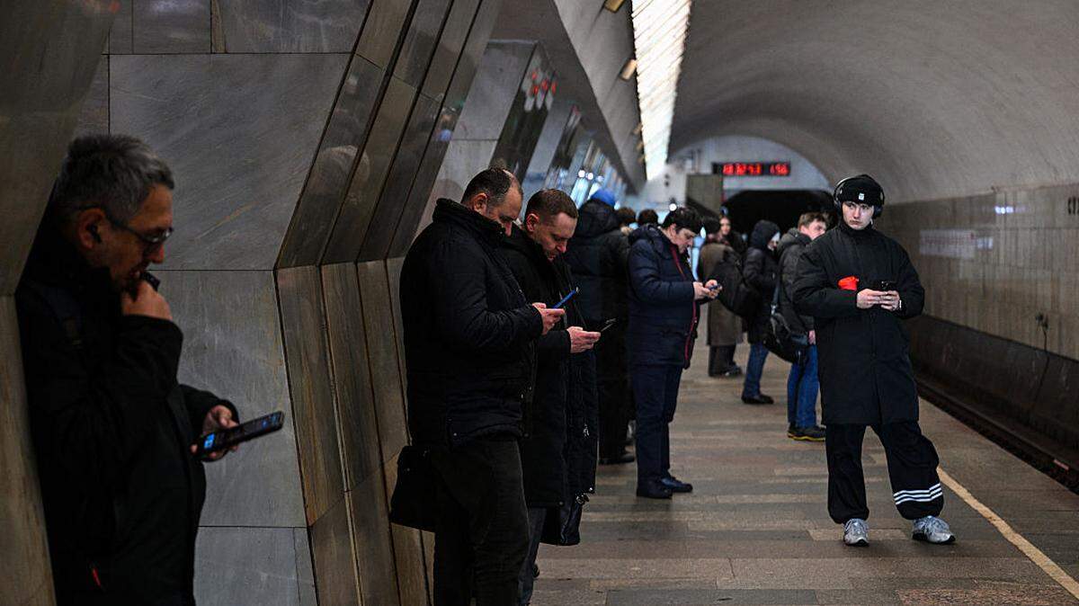 Personas miran sus celulares mientras esperan un tren del metro en Moscú, Rusia, el 12 de febrero de 2026. 