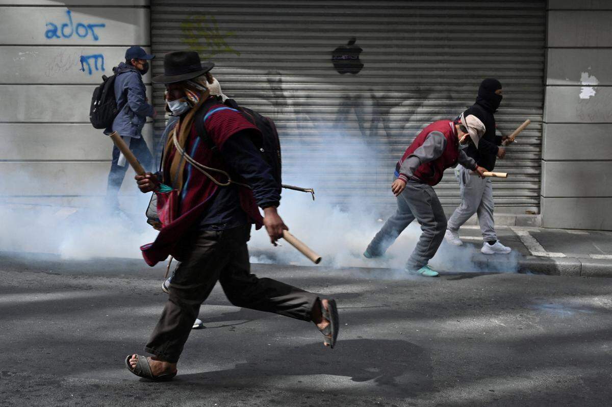 Un manifestante corre mientras los manifestantes chocan con las fuerzas del orden durante una marcha pidiendo la renuncia del presidente de Bolivia, Rodrigo Paz, mientras la crisis económica y de combustible del país empeora debido a la escasez de dólares estadounidenses y la caída de la producción nacional de energía, en La Paz, Bolivia, el lunes 18 de mayo, 2026.