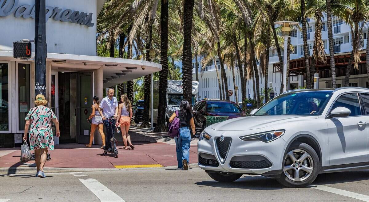 Un automóvil pasa mientras peatones cruzan la intersección de Lincoln Road y Collins Avenue el jueves 11 de junio de 2026.