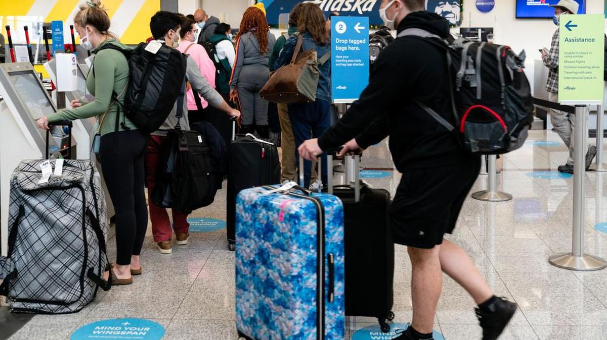 Viajeros esperan en la fila para registrar su equipaje en el mostrador de boletos de Alaska Airlines en el Aeropuerto Internacional Hartsfield-Jackson de Atlanta en Atlanta, Georgia. Foto de Bloomberg por Elijah Nouvelage