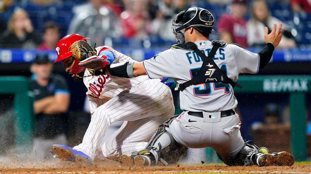 El pelotero de los Filis Edmundo Sosa (izq.) anota una carrera en el sexto inning del partido ante los Marlins de Miami, celebrado el el 6 de septiembre de 2022 en Filadelfia.