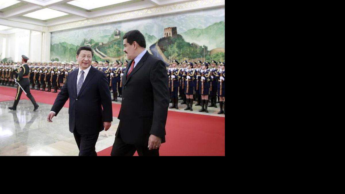 El presidente chino, Xi Jinping (izq), y su homólogo venezolano, Nicolás Maduro (dcha), pasan revista a la guardia de honor durante la ceremonia de bienvenida celebrada en el Gran Palacio del Pueblo de Pekín (China) el 7 de enero de 2015. 