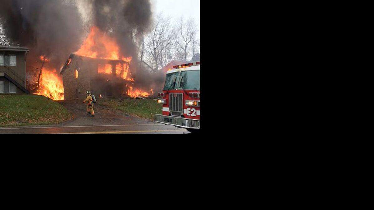 Un bombero camina frente a un edificio de apartamentos en llamas donde chocó un pequeño avión ejecutivo, el martes 10 de noviembre de 2015, en Akron, Ohio.