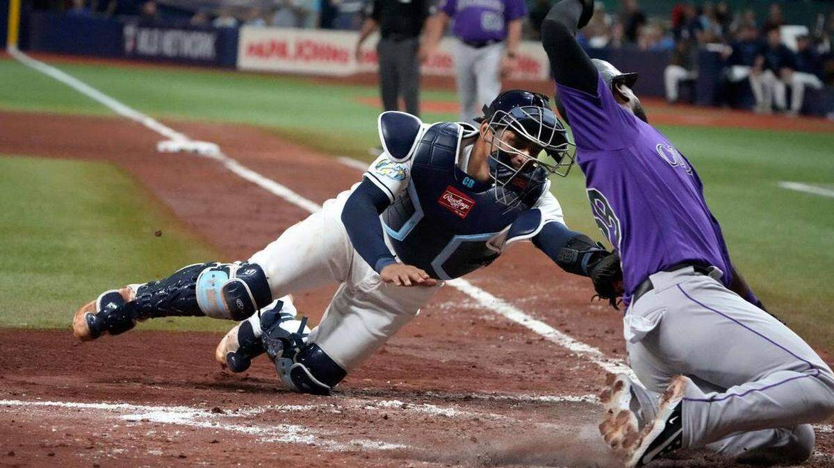 El receptor de los Rays, Christian Bethancourt (14), pone out al jardinero de los Rockies, Jurickson Profar (29), durante la sexta entrada en Tropicana Field en juego efectuado el 23 de agosto del 2023.