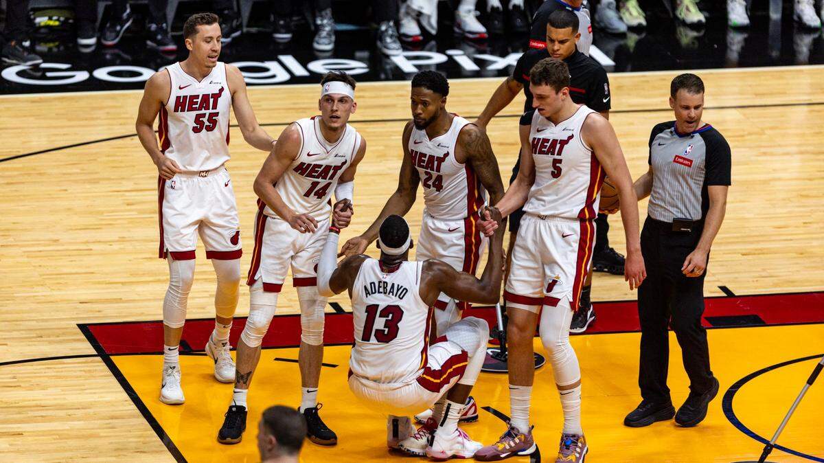 Los jugadores de Miami Heat Tyler Herro (14), Haywood Highsmith (24), Duncan Robinson (55) y Nikola Jovic (5) ayudan a su compañero Bam Adebayo (13) durante la primera mitad del tercer juego de un playoff de primera ronda de baloncesto de la NBA. Serie en Kaseya Center en Miami, Florida, el sábado 27 de abril de 2024.