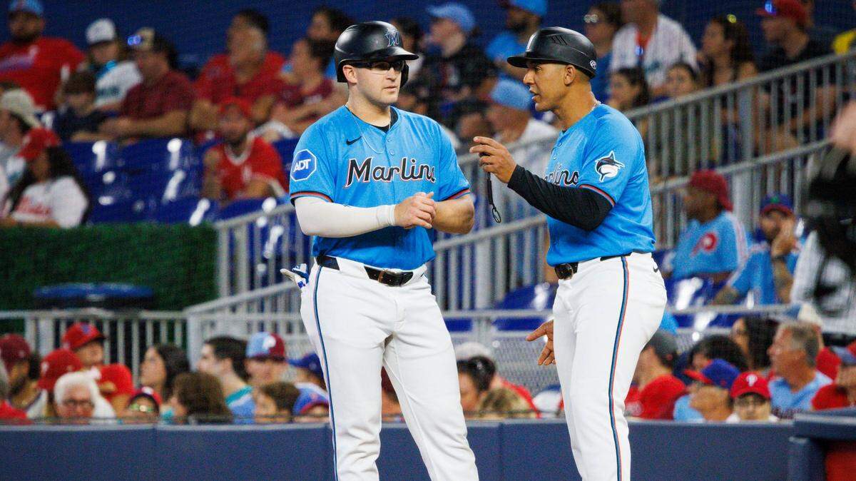 El coach de primera base de los Marlins Jon Jay (der.) habla con Jonah Bride en el primer inning del partido ante los Filis de Filadelfia, celebrado el 8 de septiembre de 2024 en Miami.