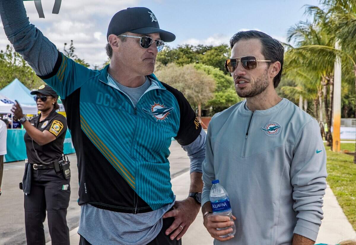 El vicepresidente y ejecutivo principal de los Dolphins Tom Garfinkel (izq.) habla con el nuevo entrenador del equipo Mike McDaniel durante el Dolphins Challenge Cancer, celebrado el 26 de febrero de 2022 en el Hard Rock Stadium de Miami Garden, Florida.