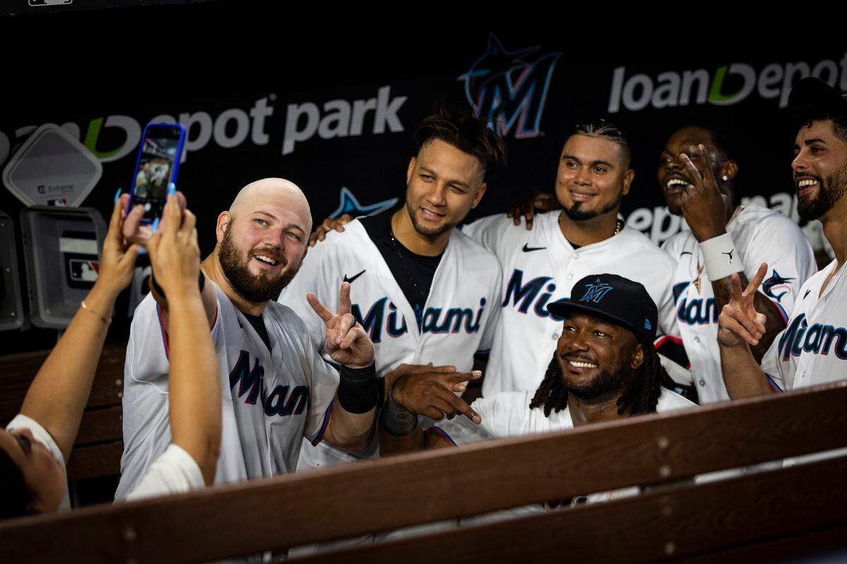 El tercera base de los Marlins Jake Burger se toma una foto con sus compañeros de equipo tras pegar el hit que le dio el triunfo a su club ante los Yankees de Nueva York, en el partido celebrado el 13 de agosto de 2023 en Miami.