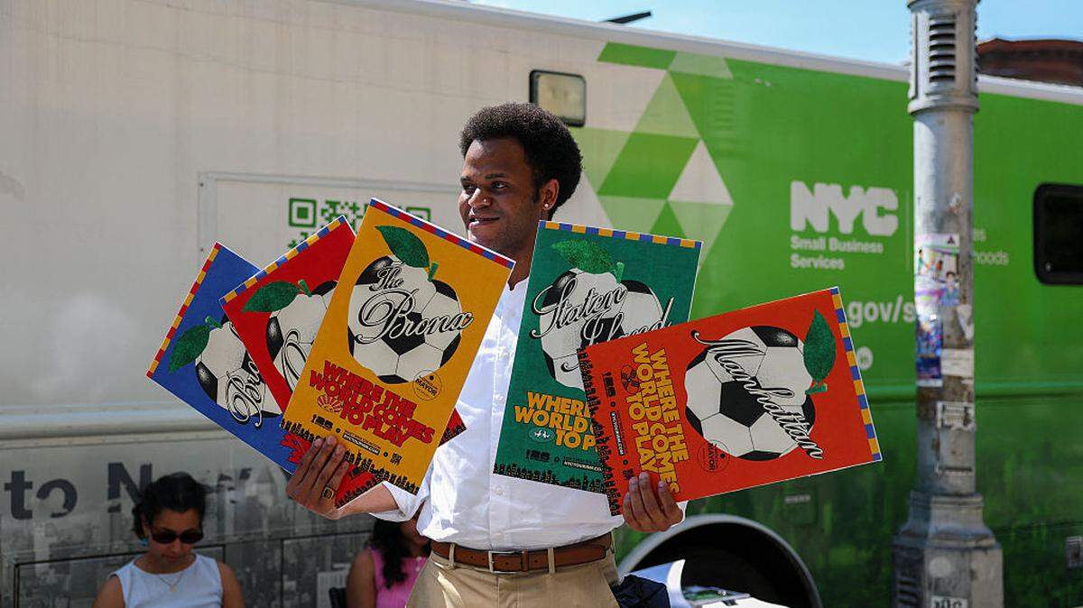 Jacques Brunvil, del Departamento de Servicios para Pequeñas Empresas de la ciudad de Nueva York, sostiene un cartel de la Copa Mundial de la FIFA 2026 durante un evento de difusión organizado por dicho departamento en el barrio neoyorquino de “Little Haiti”, el martes 19 de mayo de 2026.