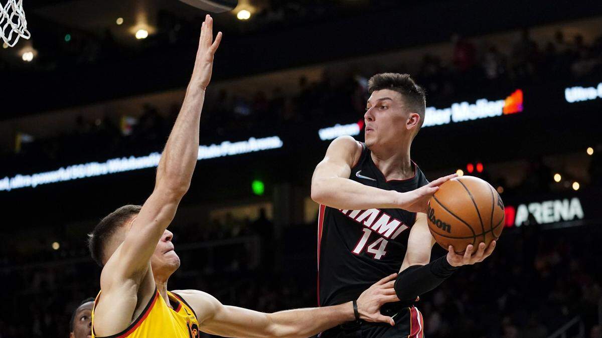 El jugador del Heat Tyler Herro (der.) trata de pasar la pelota ante la marca de Bogdan Bogdanovic, de los Hawks, el 12 de enero de 2022 en Atanta.