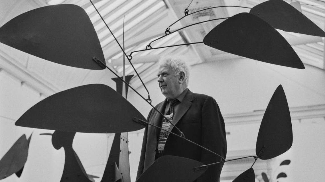 El escultor Alexander Calder de pie junto a una de sus esculturas móviles, Tate Gallery, Londres, 3 de julio de 1962. 