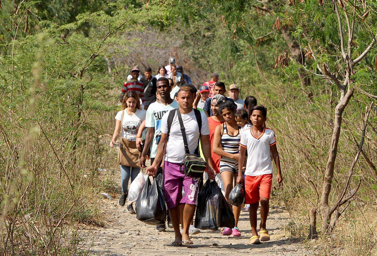 Aunque la frontera entre Colombia y Venezuela está cerrada desde hace dos días, un flujo constante de personas se mueve en ambas direcciones, como este a lo largo de una trocha junto al Puente Internacional Simón Bolívar, en Cúcuta, Colombia, en una imagen del unes 25 de febrero del 2019.