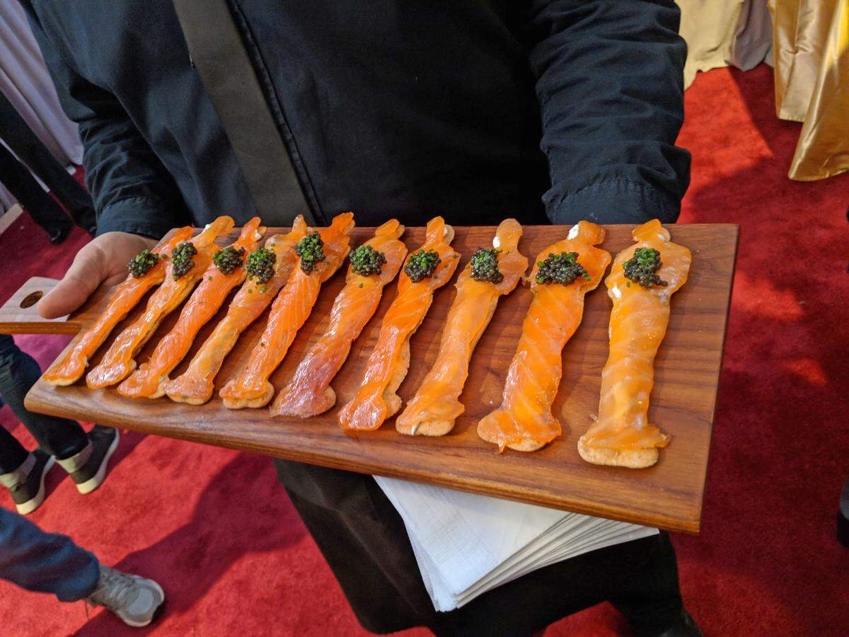 Son fuente de vitamina D en el plano animal especialmente los pescados grasos (arenque, salmón, atún) y el aceite de hígado de pescado. Vista de una tabla con salmón ahumado en forma de estatuilla del Óscar preparado para el menú del Governor’s Ball .