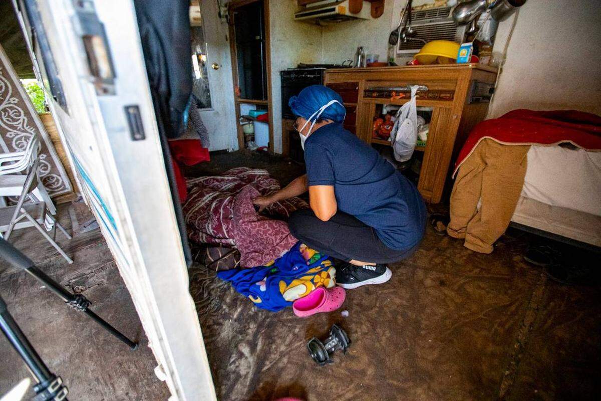 Una empleada de las escuelas públicas de Miami-Dade trata de despertar a un niño que se quedó dormido para que empezara junto a otros el día escolar el 21 de mayo de 2020.