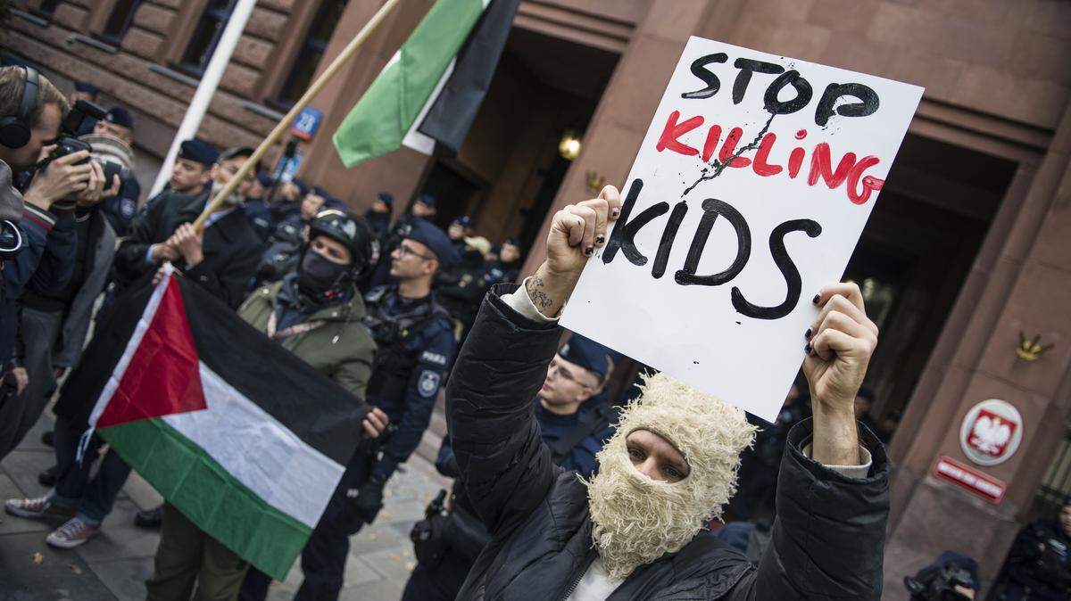 Manifestantes con banderas palestinas y pancartas protestan contra la guerra en Gaza y en apoyo a la flotilla Global Sumud, el domingo 5 de octubre de 2025, en Varsovia, Polonia. La pancarta dice “Paren de matar niños”.
