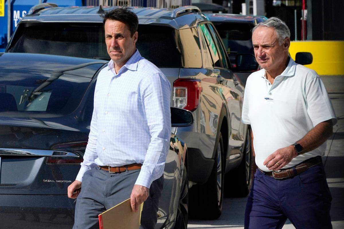 El subcomisionado de la MLB Dan Halem y el comisionado Rob Manfred caminan afuera del Estadio Roger Dean para reunirse con los jugadores y buscar un acuerdo para poner fin al paro patronal, el lunes 28 de febrero del 2022 en Jupiter, Florida.