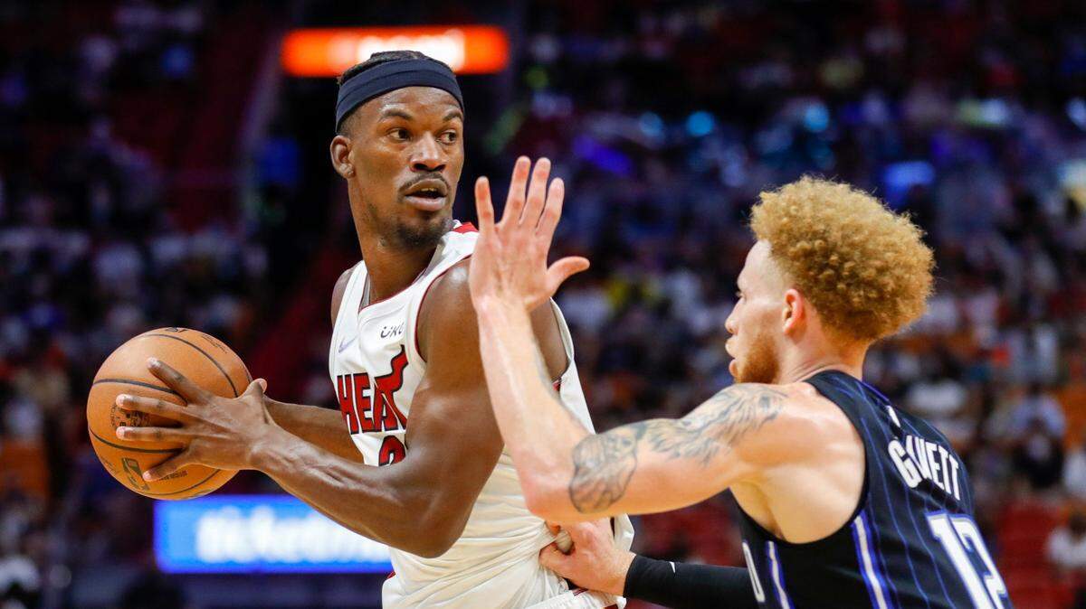 El jugador del Heat Jimmy Butler trata de pasar la pelota ante la marca de Admiral Schofield, del Magic de Orlando, en el partido celebrado el 26 de diciembre de 2021 en Miami.