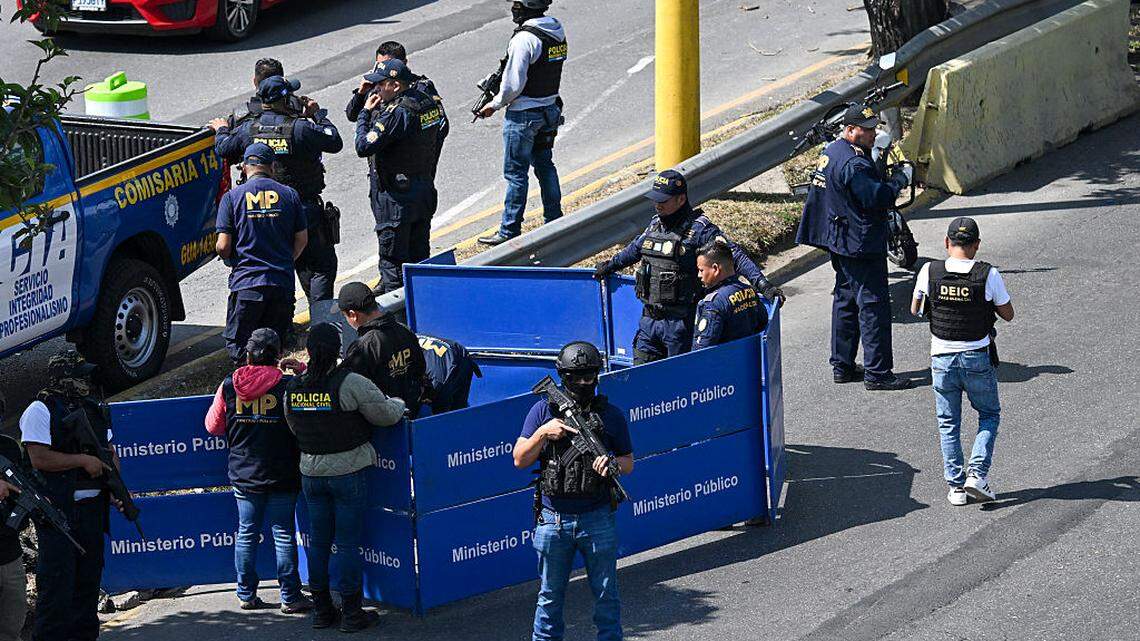 Agentes de policía permanecen de guardia mientras los fiscales del Ministerio Público recogen pruebas en el lugar donde un agente de policía fue asesinado por presuntos miembros de pandillas, en la Ciudad de Guatemala, el domingo 18 de enero de 2026.