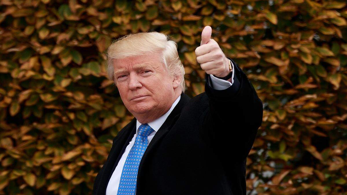 El presidente electo Donald Trump saluda a la prensa tras llegar a su propiedad Trump International Golf Club para reunirse con varios políticos, el 20 de noviembre del 2016 en Bedminster Township, Nueva Jersey. 