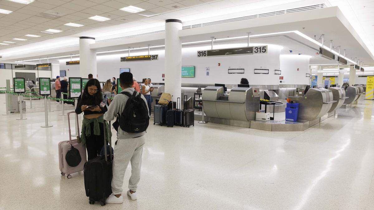 Dos personas se registran para su vuelo de Viva Aerobus en una nueva cabina de venta de boletos en la Terminal Central durante el día el pasado 19 de agosto en el Aeropuerto Internacional de Miami.