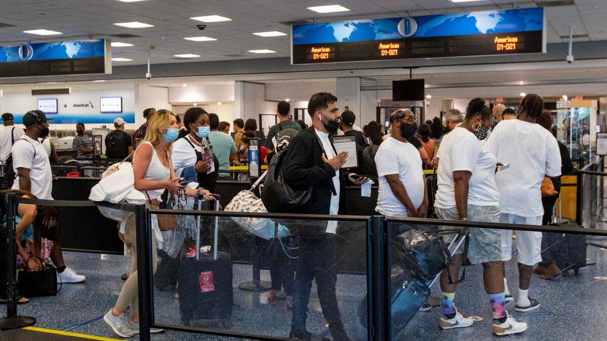 Viajeros esperan en fila para pasar por seguridad en el Aeropuerto Internacional de Miami, el lunes 7 de junio de 2021.